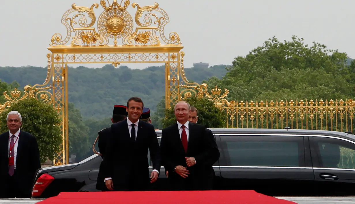 Presiden Prancis Emmanuel Macron dan Presiden Rusia, Vladimir Putin berjalan masuk ke Istana Versailles, dekat Paris, Senin (29/5). Macron bertemu tatap muka untuk pertama kalinya dengan Vladimir Putin. (AP Photo/Francois Mori, pool)