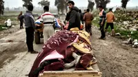 Warga memanfaatkan gerobak untuk mengangkut kerabatnya yang tewas akibat serangan udara di tengah konflik tentara Irak dan ISIS di Mosul, Irak, Jumat (17/3). (AFP PHOTO/ARIS MESSINIS)