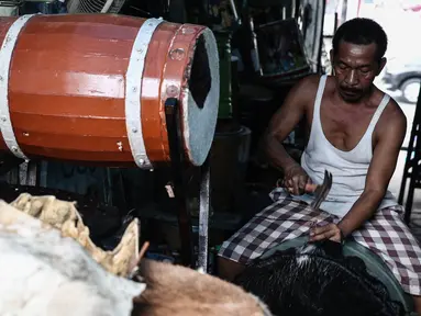 Ridho (52) memasang pengikat untuk membuat bedug di kawasan, Tanah Abang, Jakarta, (17/6). Menjelang lebaran, sejumlah pedagang menjual aneka ragam bedug yang dijual dari harga Rp. 100 ribu hingga Rp 4 juta. (Liputan6.com/Faizal Fanani)