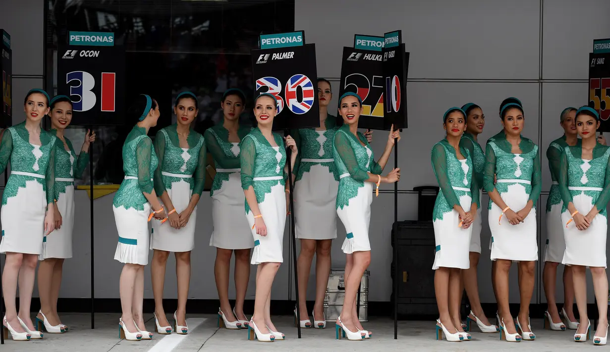 Gadis Grid atau Grid Girls berpose sebelum Grand Prix Formula 1 Malaysia di Sepang, (1/10/2017). Keberadaan gadis grid sudah dihapus di ajang Kejuaraan V8 Supercars pada musim 2016. (AFP PHOTO / Manan Vatsyayana)