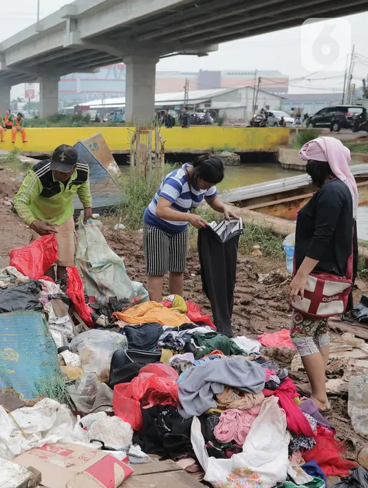 Warga memilah sampah sisa banjir yang menumpuk di kawasan Cipinang Melayu, Jakarta, Rabu (8/1/2020). Banjir yang melanda Jakarta dan sekitarnya sejak 1 Januari 2020 lalu menyisakan tumpukan sampah di sejumlah titik. (Liputan6.com/Herman Zakharia)