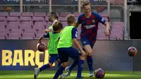 Gelandang Frenkie de Jong menggiring bola saat bermain dengan anak-anak selama pengenalan dirinya sebagai pemain baru Barcelona di stadion Camp Nou, Spanyol (5/7/2019). (AFP Photo/Lluis Gene)