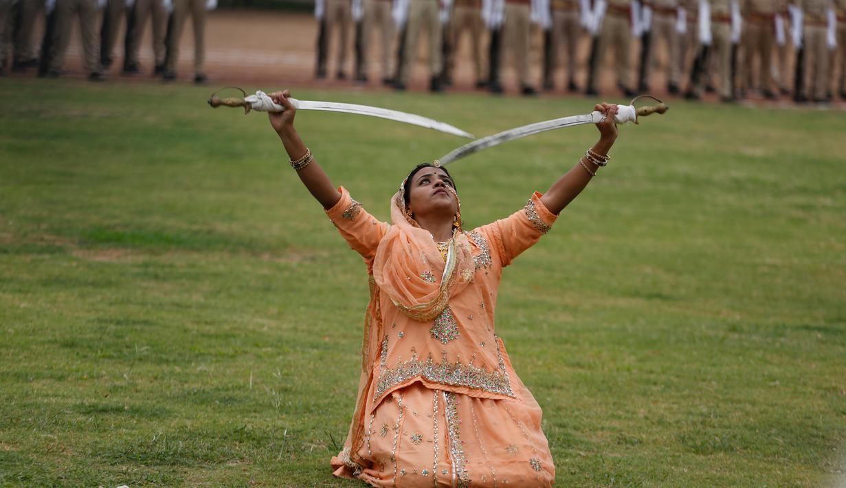Seorang wanita India beraksi menggunakan dua pedang selama perayaan hari Kemerdekaan di Ahmadabad, India, (15/8). India merdeka dari kolonialis Inggris pada tahun 1947. (AP Photo / Ajit Solanki)