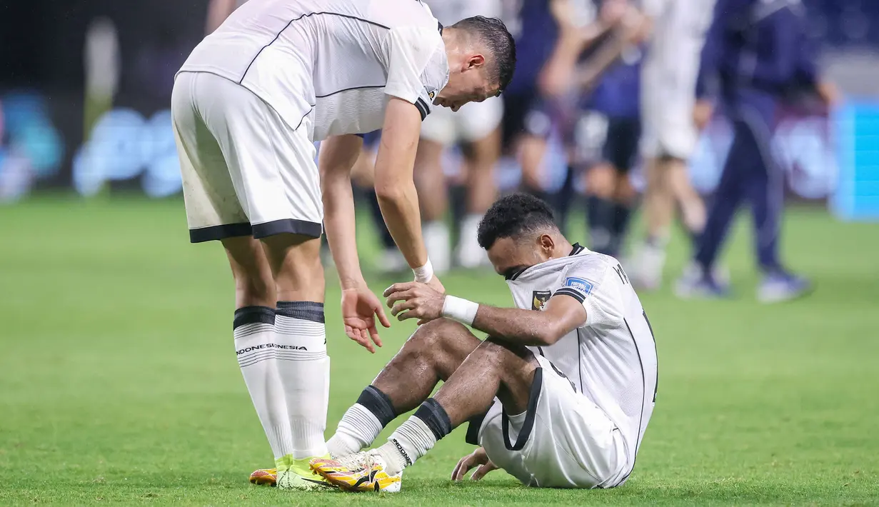Pemain Timnas Indonesia, Jay Idzes (kiri) memberikan dukungan kepada Yance Sayuri yang tak mampu membendung kesedihannya setelah laga terakhir putaran ketiga Grup C Kualifikasi Piala Dunia 2026 melawan Jepang di Suita Stadium, Jepang, Selasa (10/06/2025). (AFP/Paul Miller)