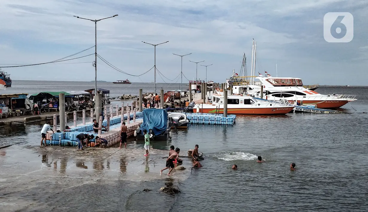 Anak-anak berenang di dermaga saat banjir rob merendam Pelabuhan Kali Adem, Muara Angke, Jakarta, Kamis (22/10/2020). Banjir rob yang merendam kawasan Pelabuhan Kali Adem sejak lima hari lalu dimanfaatkan oleh anak-anak setempat untuk berenang di sekitar dermaga. (merdeka.com/Iqbal S. Nugroho)