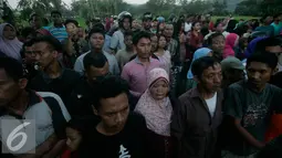 Warga memadati lokasi helikopter jatuh yang sudah di tutup terpal di Dusun Kowang, Sleman (8/7). Heli jatuh setelah melakukan penerbangan dari Solo menuju Yogyakarta. (Liputan6.com/Boy Harjanto)
