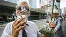 Aktivis Ray Turmel menghisap ganja medis sambil membawa plastik berisi ganja di luar gedung pemilihan federal Munk Debat, Toronto, Kanada (28/9/2015). Ray Turmel  menginginkan ganja di negaranya dilegalkan untuk kepentingan medis. (REUTERS/Mark Blinch)