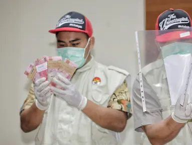 Petugas menunjukkan barang bukti uang hasil OTT terhadap Ketum PPP Romahurmuziy, di gedung KPK, Jakarta, Sabtu (16/3). KPK menetapkan Romahurmuziy sebagai tersangka suap pengisian jabatan di Kementerian Agama (Kemenag). (Liputan6.com/Faizal Fanani)