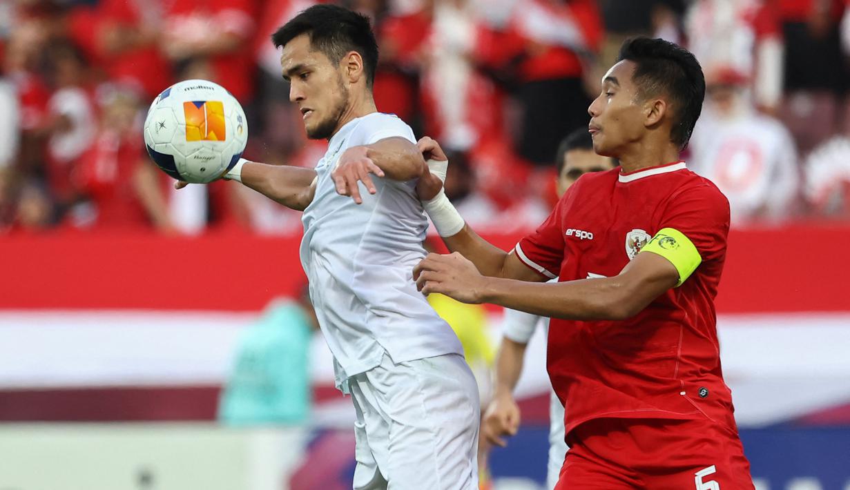 <p>Pemain Uzbekistan U-23, Ulugbek Khoshimov (kiri) menguasai bola dibayangi kapten Timnas Indonesia U-23, Rizky Ridho pada laga semifinal Piala Asia U-23 2024 di Abdullah bin Khalifa Stadium, Doha, Qatar, Senin (29/4/2024). (AFP/Karim Jaafar)</p>