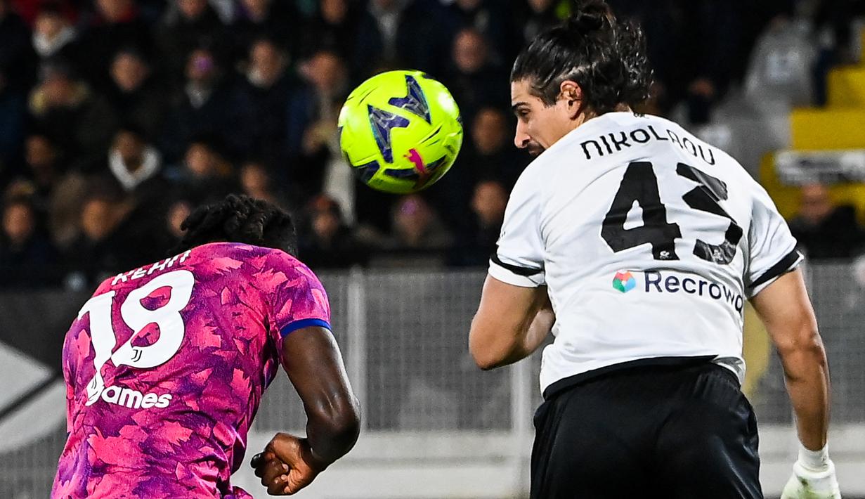 Pemain Juventus Moise Kean (Kiri) berebut bola udara dengan pemain Spezia Dimitrios Nikolaou pada pertandingan sepak bola Liga Italia di Stadion Alberto-Picco, La Spezia, Italia, 19 Februari 2023. Juventus mengalahkan Spezia dengan skor 2-0. (ANDREAS SOLARO/AFP)