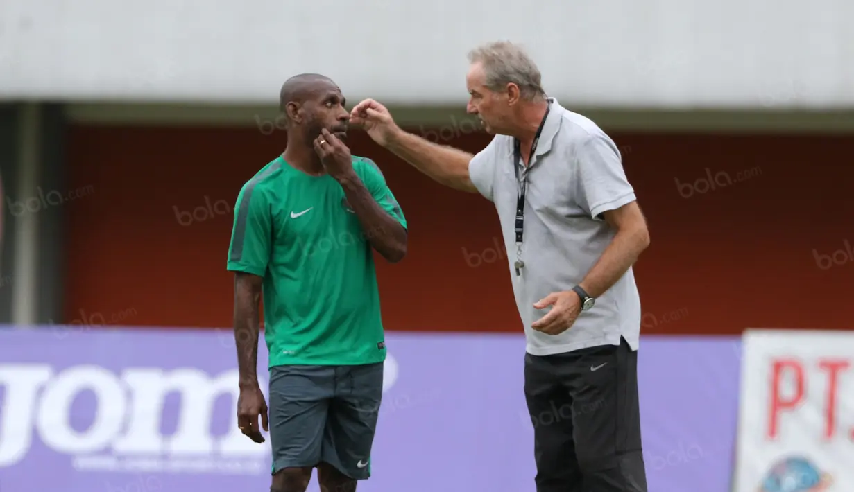 Alfred Riedl dan Boaz Solossa tengah berbincang saat sesi latihan di Stadion Maguwoharjo, Sleman, Jumat (07/10/2016). (Bola.com/Nicklas Hanoatubun)