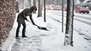 Seorang wanita membersihkan trotoar dari salju tebal di Aalborg, Denmark, Selasa (27/2). Cuaca dingin yang dijuluki "The Beast from the East" membuat suhu di sebagian Eropa turun. (AFP PHOTO/Scanpix DAN Ritzau SCANPIX/Henning Bagger/Denmark OUT)