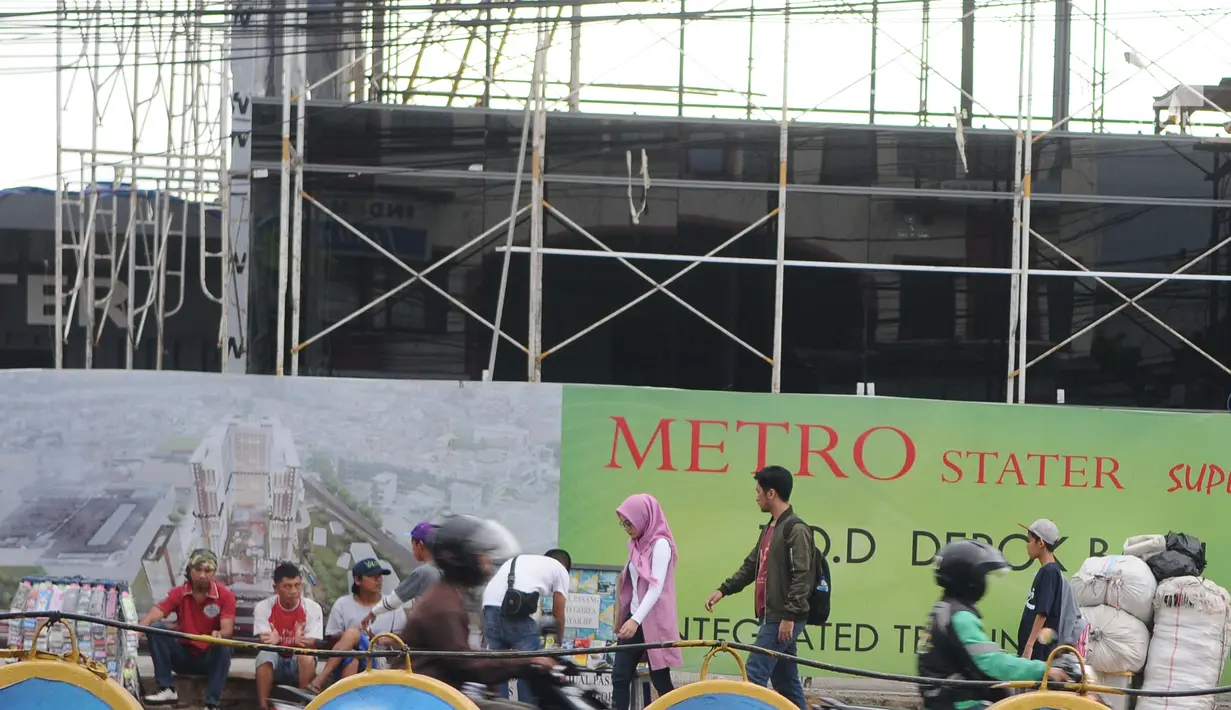 Pejalan kaki melintasi pedagang kaki lima (PKL) di depan Terminal Depok, Jawa Barat, Kamis (17/1). Trotoar Terminal Depok tidak bisa digunakan pejalan kaki menjelang sore lantaran diokupasi PKL. (Liputan6.com/Herman Zakharia)