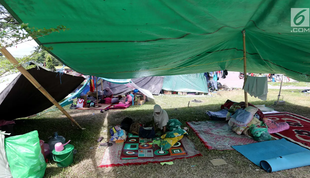 Pengungsi korban gempa dan tsunami Palu beristirahat di tenda pengungsian lapangan Walikota Palu, Sulawesi Tengah, Senin (8/10). Nantinya, pemerintah akan memindahkan pengungsi yang masih bertahan di tenda ke barak pengungsian. (Liputan6.com/Fery Pradolo)
