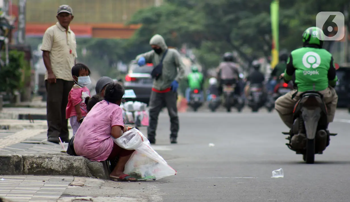 Pemulung duduk duduk di trotoar Jalan Margonda Raya, Depok, Kamis (16/4/2020). Pandemi COVID-19 memberikan dampak yang sangat besar bagi sosial dan ekonomi Indonesia. Bahkan yang paling dikhawatirkan bertambahnya angka kemiskinan dan pengangguran. (Liputan6.com/Helmi Fithriansyah)