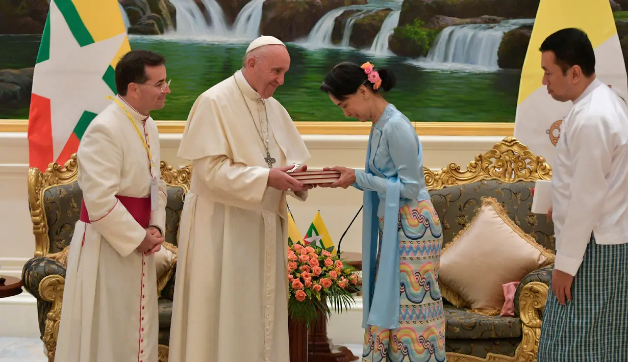 Pemimpin de facto Myanmar, Aung San Suu Kyi menerima cendera mata dari Paus Fransiskus di Naypyitaw, Selasa (28/11). Paus Fransiskus bertemu dengan Suu Kyi untuk membahas mengenai krisis kemanusiaan di Rakhine. (L'Osservatore Romano/Pool photo via AP)