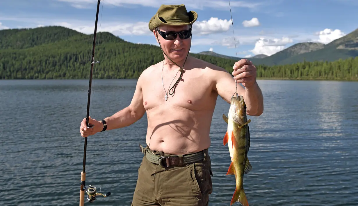 Presiden Rusia Vladimir Putin menunjukkan ikan yang didapat saat memancing selama liburan mini di kawasan Siberia Tyva. Foto dirilis oleh biro pers Kremlin, pada 5 Agustus 2017. (Alexei Nikolsky / Sputnik, Foto Kolam Kremlin via AP)