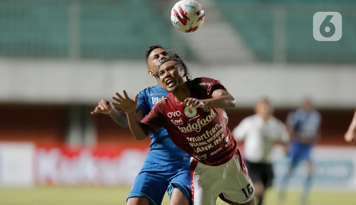 Pemain Bali United, Hariono (kanan), berebut bola dengan pemain Persib Bandung, Wander Luiz Queiroz Dias, dalam pertandingan Babak Penyisihan Piala Menpora 2021 di Stadion Maguwoharjo, Sleman. Rabu (24/3/2021). (Bola.com/Arief Bagus)