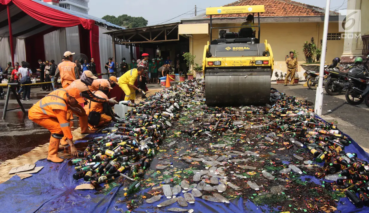 Petugas memusnahkan barang bukti miras dan narkoba di halaman Polsek Palmerah, Jakarta Barat, Senin (14/5). Pemusnahan dilakukan untuk menciptakan suasana kondusif menjelang bulan suci Ramadan. (Liputan6.com/Arya Manggala)