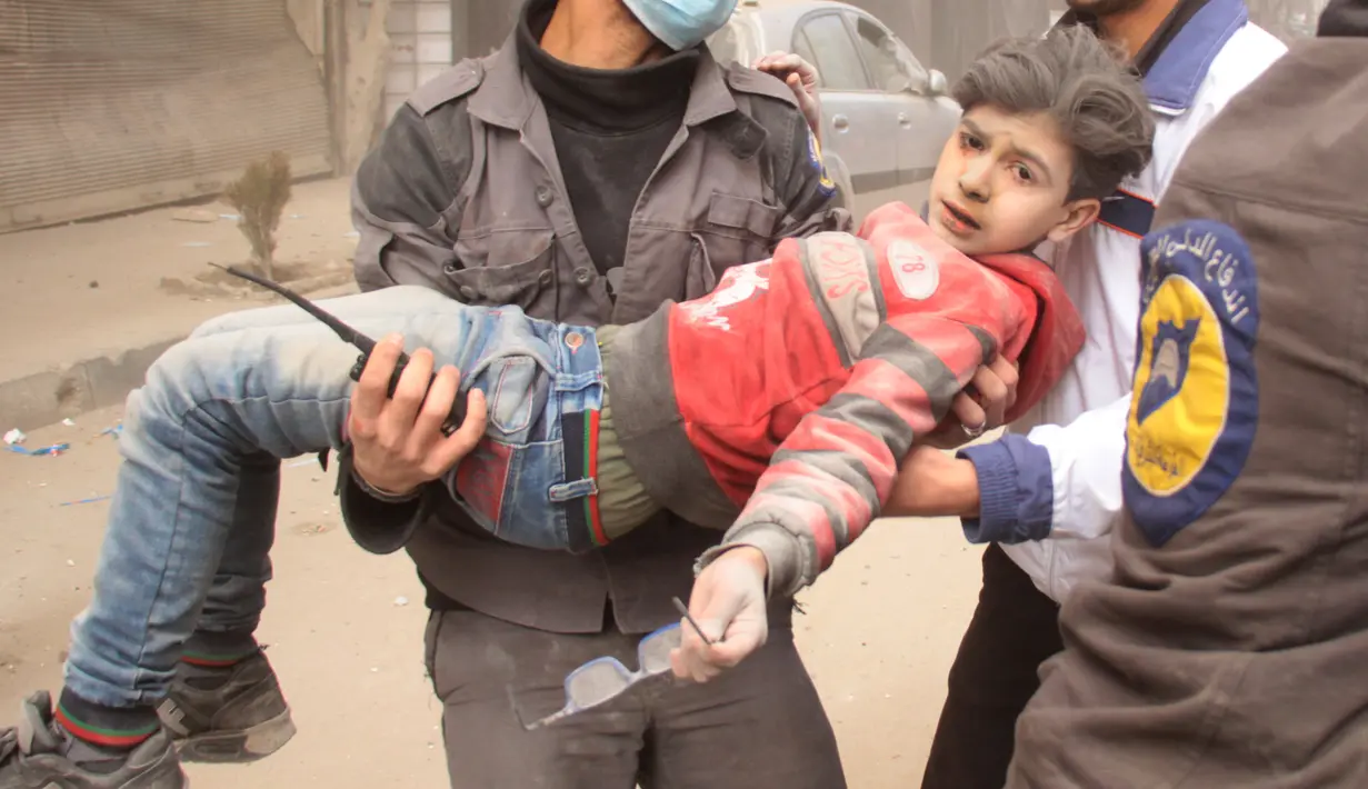 Ekspresi seorang anak yang diselamatkan usai terjadi serangan udara dari pasukan Assad di wilayah Ghouta timur, Suriah (7/2). Dalam serangan ini dilaporkan sedikitnya, 47 warga sipil tewas. (AFP Photo/Hamza Al-Ajweh)
