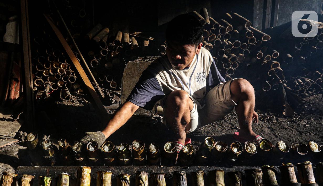 Pekerja melakukan pembakaran lemang bambu di Jalan Kramat Raya, Senen, Jakarta Pusat, Rabu (6/4/2022). Makanan khas Sumatera Barat yang cocok dijadikan sebagai menu berbuka puasa tersebut dijual dengan harga Rp 15.000 - Rp 30.000. (Liputan6.com/Herman Zakharia)