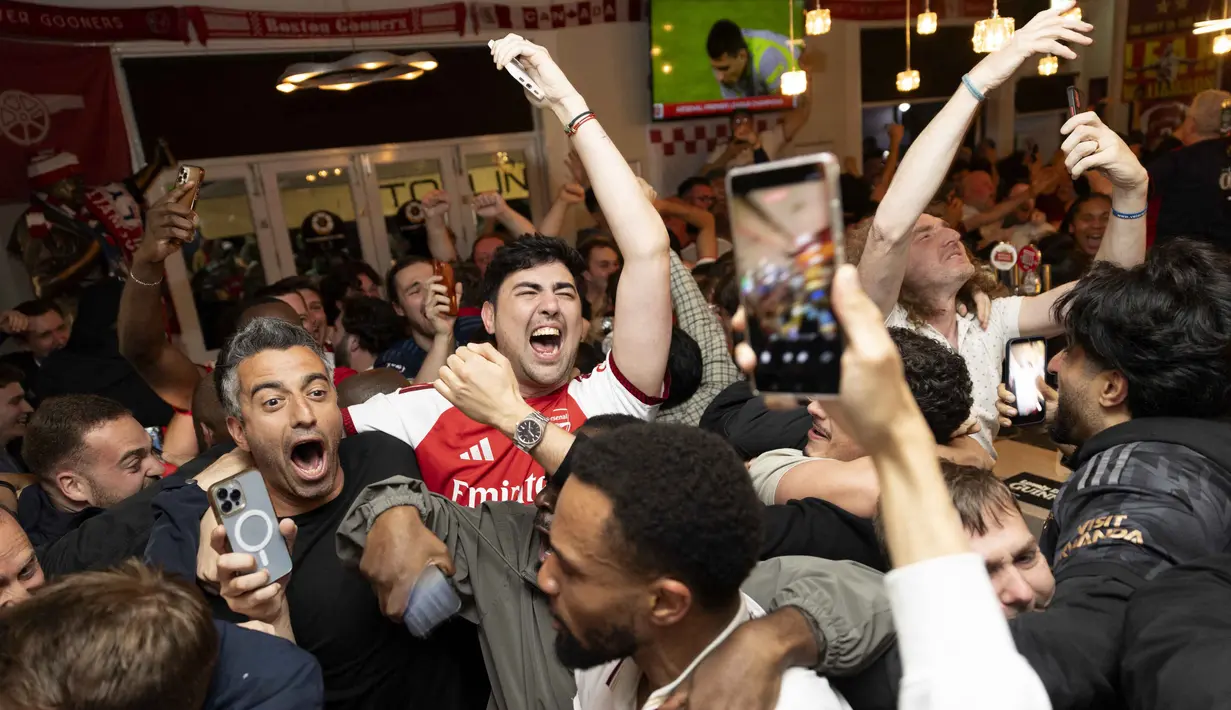 Para penggemar Arsenal merayakan kemenangan tim mereka di Liga Primer Inggris, dari dalam pub Tollington Arms dekat Stadion Emirates, London, Inggris, pada 19 Mei 2026. (Brook Mitchell/AFP)