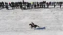Pandangan dari udara menunjukkan seorang penunggang kuda berlomba di Sungai Yenisei yang tertutup es selama balapan kuda amatir Derby Es tahunan di dekat pemukiman Siberia di Novosyolovo, selatan Krasnoyarsk, Rusia (17/3). (Reuters/Ilya Naymushin)