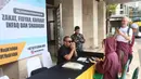 Zakat fitrah juga menjadi sarana berbagi agar fakir miskin dapat merasakan kebahagiaan di Hari Raya Idul Fitri. Tampak dalam foto, petugas Unit Pengelola Zakat (UPZ) melayani pembayaran zakat, fidyah, kafarat, infaq, dan shadaqah di teras Masjid Istiqlal, Jakarta, Minggu 15 Maret 2026. (Kapanlagi.com/Budy Santoso)