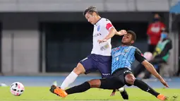 Penyerang Yokohama FC Kazuyoshi Miura (kiri) dijegal oleh bek Kawasaki Frontale, Jesiel Cardoso Miranda selama pertandingan J-League di stadion Atletik Todoroki di Kawasaki pada 23 September 2020. Menurut laman transfermarkt, Kazuyoshi Miura atau yang dikenal luas dengan sapan King Kazu memiliki nilai pasar sebesar 100 juta euro atau setara Rp. 1,6 triliun (asumsi kurs Rp. 16.600 per euro). (AFP/JIJI PRESS )