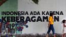Warga melintas di depan tulisan mural di Lapangan Kebagusan, Jakarta, Rabu (15/2). Jelang menggunakan hak pilihnya pada Pilkada, Ketua Umum PDI-P Megawati Soekarnoputri menggoreskan tinta pada salah satu gambar. (Liputan6.com/Helmi Fithriansyah)