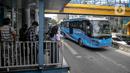 Sejumlah calon penumpang menunggu kedatangan bus Transjakarta di Halte Harmoni, Jakarta, Senin (10/1/2022). PT Transportasi Jakarta (Transjakarta) melakukan penyesuaian jam operasional usai ditetapkannya status PPKM menjadi Level 2 di Jakarta. (Liputan6.com/Faizal Fanani)