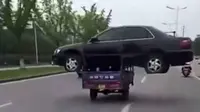 Seorang pria asal China menjadi viral setelah mengendarai sepeda motor roda tiga mengangkut sedan.