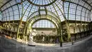 Sebuah  arena ice skating di bawah kubah kaca mewah legendaris, Grand Palais, Paris, Senin (17/12). Tempat seluas 1.800 meter persegi ini menjadi arena ice skating sementara terbesar di Prancis. (STEPHANE DE SAKUTIN / AFP)