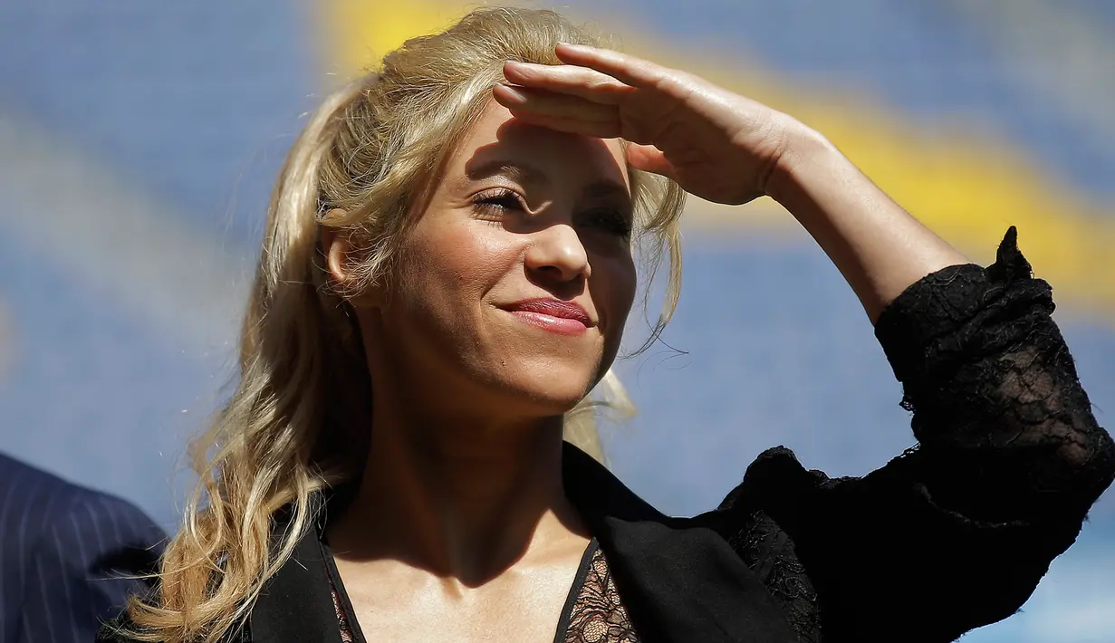 Penyanyi Kolombia, Shakira berdiri di bawah terik matahari saat menghadiri acara amal di Stadion Camp Nou di Barcelona, Selasa (28/3). Shakira akan membangun sekolah bekerja sama dengan klub Barcelona dan Yayasan La Caixa.(AP Photo/Manu Fernandez)