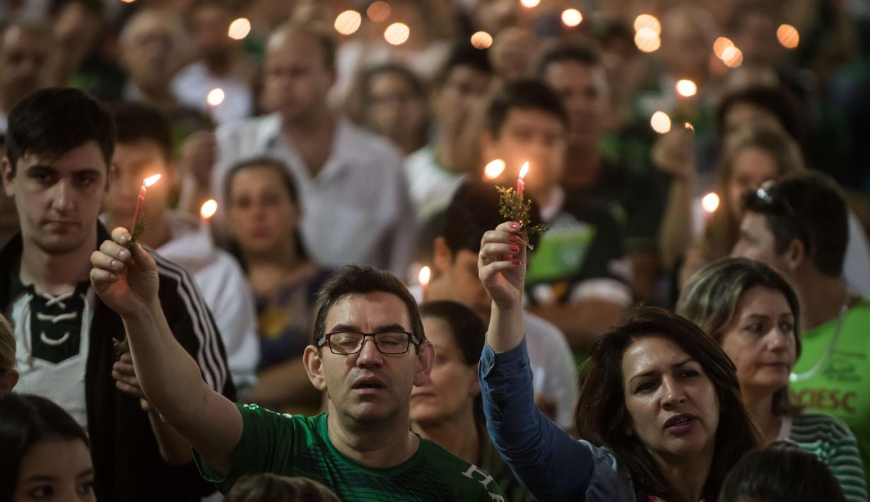 Eskpresi fans Chapecoense yang bernyanyi saat memperingati satu tahun kecelakaan pesawat Lamia 2933 di Arena Conda stadium, Chapeco, Santa Catarina, Brasil, (28/11/2017). Sekitar 19 pemain Chapecoense meninggal. (AFP/Nelson Meida)