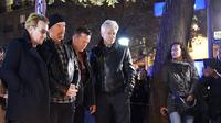 Grup band U2 Bono, Adam Clayton , Larry Mullen Jr dan The Edge seusai meletakkan karangan bunga di trotoar di depan gedung pertunjukan Bataclan Theatre, salah satu tempat serangan teroris di Paris, Perancis, Sabtu (14/11). (AFP PHOTO / FRANCK FIFE)
