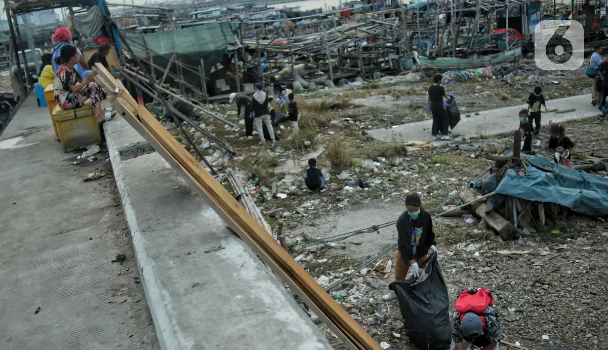 Anak-anak pesisir dan sukarelawan saat membersihkan sampah di Pemukiman Nelayan Manunggal, Cilincing, Jakarta Utara, Minggu (18/9/2022). Tumpukan sampah yang berserakan di kawasan pemukiman nelayan Manunggal, Cilincing menginisasi Kelas Jurnalis Cilik untuk membersihkan sampah dan mengedukasi kepada anak-anak pesisir serta masyarakat pentingnya menjaga kebersihan di lingkungan sekitar. (merdeka.com/Iqbal S. Nugroho)