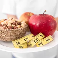 Sebuah piring dengan buah apel, kacang, dan pengukur badan (Foto Dok: Freepik/pvproductions).