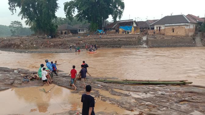 Evakuasi hanya mengandalkan perahu karet yang diikat ke sebuah tali, lalu ditarik oleh warga di tengah derasnya aliran Sungai Ciberang, di Kecamatan Sajira, Kabupaten Lebak, Banten. (Liputan6.com/ Yandhi Deslatama)