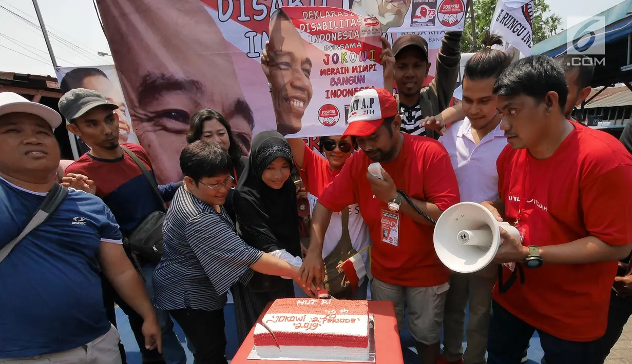 Sejumlah anggota Disabilitas Indonesia Pospera (Posko Perjuangan Rakyat)  Tuna Rungu Indonesia saat memotong kue seusai mendeklarasikan dukungan terhadap Joko Widodo (Jokowi)  untuk periode ke-2 di Jakarta, Minggu (19/8). (Liputan6.com/Herman Zakharia)