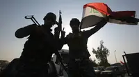 Anggota polisi Federal mengibarkan bendera nasional Irak saat merayakan keberhasilan mereka menyingkirkan militan ISIS dari Kota Tua Mosul, Minggu (9/7). ISIS merebut Mosul pada musim panas 2014. (AHMAD AL-RUBAYE/AFP)