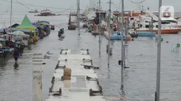 Aktivitas di dermaga pelabuhan kali Adem, Muara Angke, Jakarta, Kamis (31/12/2020). Badan Meteorologi Klimatologi dan Geofisika (BMKG) mengeluarkan peringatan dini kepada warga pesisir Jakarta untuk antisipasi banjir dan rob di malam pergantian Tahun Baru 2021. (merdeka.com/Imam Buhori)
