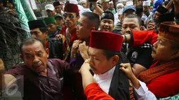 Massa mengamankan seorang pria yang diduga provokator saat sidang kasus penistaan agama di Jakarta, Selasa (10/1). Sempat terjadi kericuhan akibat peristiwa tersebut. (Liputan6.com/Immanuel Antonius)