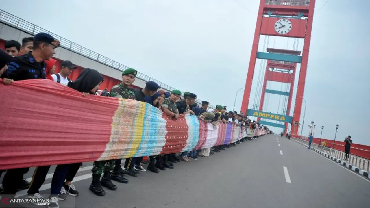 Kain Jumputan Membentang di Jembatan Ampera Sambut Jokowi