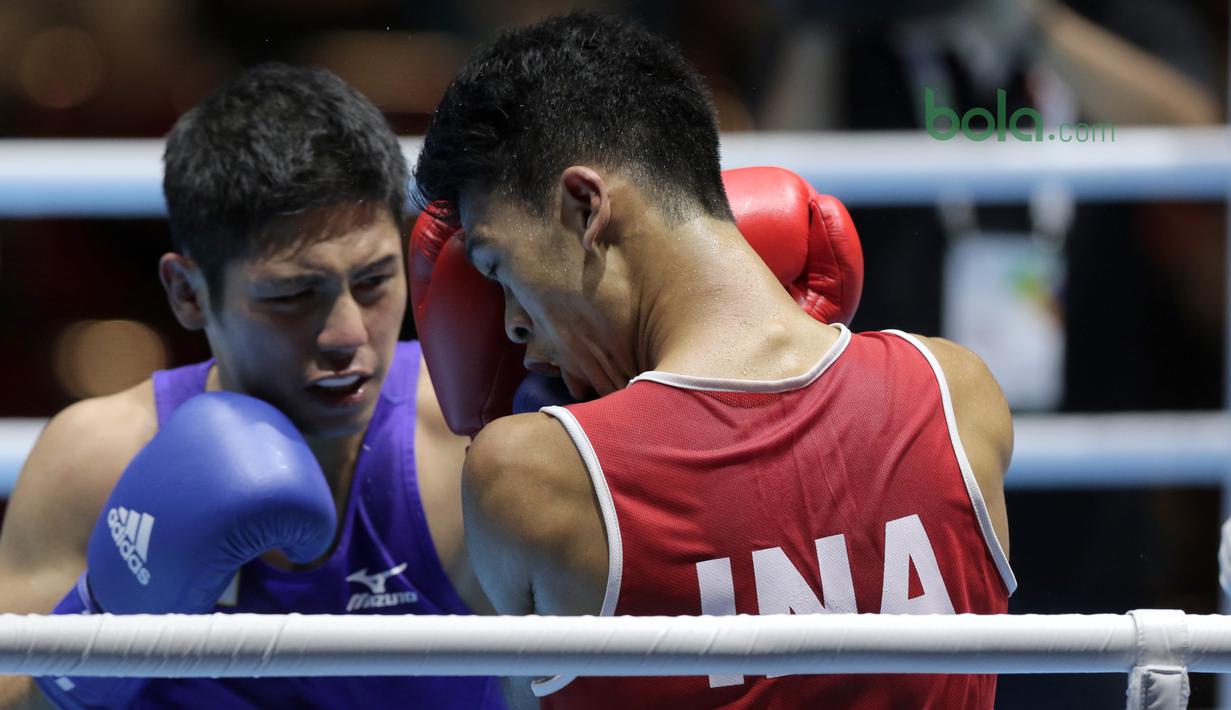 Petinju Indonesia, Grece Savon Simangunsong (merah) menangkis pukulan petinju Jepang, Hiroaki Kinjo pada semifinal Test Event Asian Games 2018 kelas Welter di Kemayoran, Jakarta (14/2/2018). Simangunsong menang dengan skor 3-2. (Bola.com/Nick Hanoatubun)