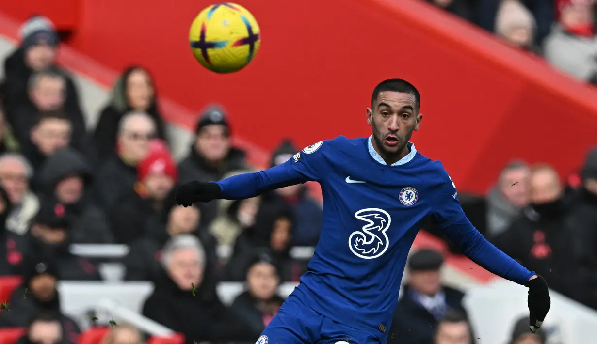 Gelandang Chelsea, Hakim Ziyech berusaha mengontrol bola saat menghadapi Liverpool pada laga Liga Inggris 2022/2023 di Anfield Stadium, Liverpool (21/1/2023). Hakim Ziyech memutuskan hijrah dari Chelsea menuju Al Nassr untuk bergabung dengan Cristiano Ronaldo meski masih menyisakan kontrak hingga 30 Juni 2025. Belum diketahui berapa nilai transfer yang dikeluarkan Al Nassr untuk Hakim Ziyech yang akan dikontrak selama 3 tahun. (AFP/Paul Ellis)
