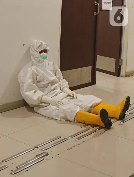 Seorang tenaga kesehatan beristirahat disela aktivitasnya di RSDC Wisma Atlet, Jakarta, Selasa (26/1/2021). Data Satgas Covid-19 per Selasa (26/1) mencatat kasus COVID-19 di Indonesia bertambah 13.094 sehingga total menyentuh angka satu juta, tepatnya 1.012.350. (Liputan6.com/Herman Zakharia)
