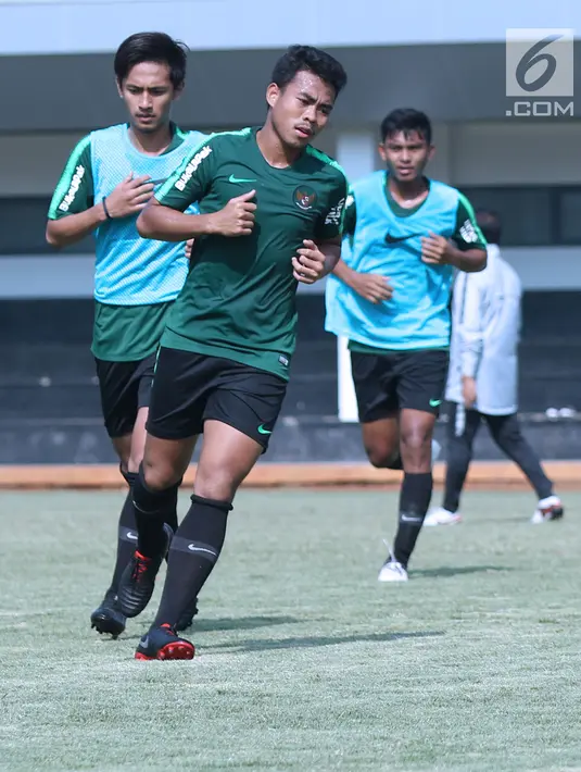 Pemain Timnas Indonesia U-19, Nur Hidayat (depan) melakukan lari pemanasan saat latihan di Lapangan B Kompleks GBK, Jakarta, Selasa (18/9). Latihan ini persiapan  PSSI Anniversary Cup U-19 dan Piala AFC U19. (Liputan6.com/Helmi Fithriansyah)