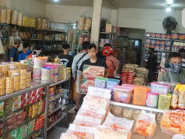 Pekerja membawa kardus berisi kue kering di salah satu toko penjualan kue kering di kawasan Ciracas, Jakarta, Selasa (19/5/2020). Adanya pandemi covid-19 diakui para pedagang menyebabkan penjualan kue kering menjelang lebaran turun hingga 50 persen. (Liputan6.com/Immanuel Antonius)