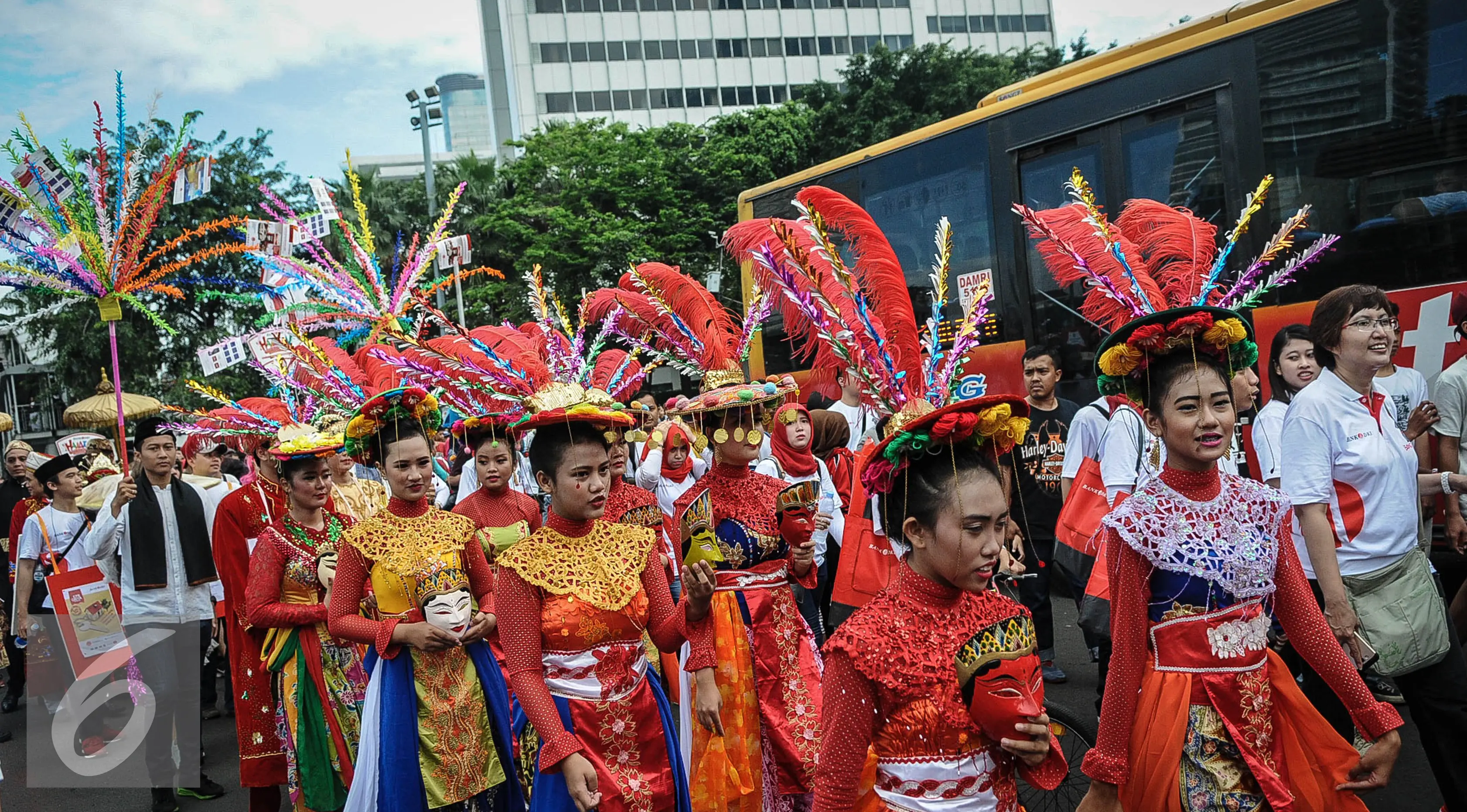 Sejumlah wanita mengenakan busana penari topeng dalam acara Hajatan Bank DKI saat Car Free Day di kawasan Bundaran HI Jakarta, Minggu (16/10). Hajatan Bank DKI ini digelar dalam bentuk karnaval kebudayaan Betawi. (Liputan6.com/Faizal Fanani)